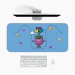 Infidu Cartoon Bird Desk Pad featuring a purple bird with glasses and a green hat, surrounded by colorful balloons and hearts on a light blue background. A desk pad under the computer