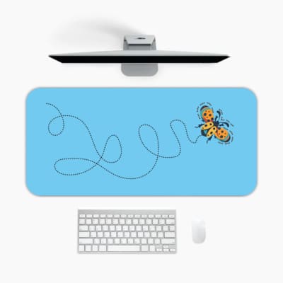 Infidu Yellow Butterfly Desk Pad featuring a yellow butterfly with a dotted flight path on a light background. A desk pad under the computer