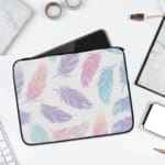 Infidu Pastel Feather Laptop Sleeve with soft fabric in pink, blue, and purple shades, featuring a zip closure for secure laptop protection. laptop sleeve kept on a plain white background