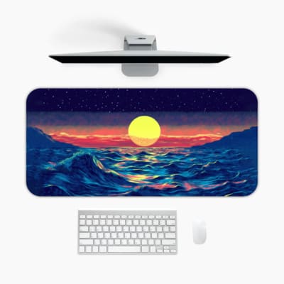 Infidu Desk Pad with an ocean sunset design, showcasing blue waves and a sky in warm tones of pink, purple, and orange for a serene look. A desk pad under the computer