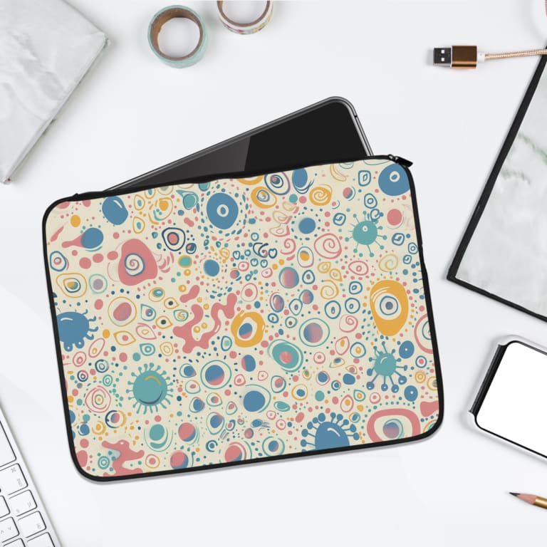 Laptop sleeve with a pastel bubble pattern in light blue, coral pink, and peach circles on a white background, secured with a zip closure. laptop sleeve kept on a plain white background