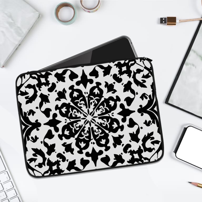 Laptop sleeve with a bold black and white floral or geometric design. laptop sleeve kept on a plain white background