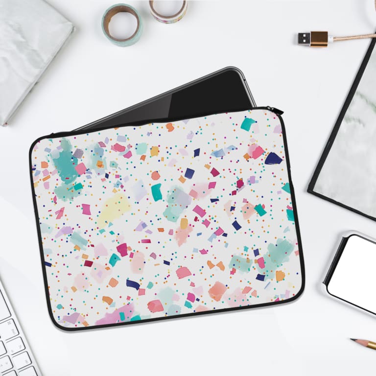 Laptop sleeve featuring a pastel terrazzo design with irregular shapes in pink, blue, turquoise, and dark shades on a light background. laptop sleeve kept on a plain white background