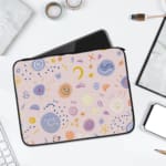 Laptop sleeve with a playful, abstract design featuring colorful shapes like swirls, circles, and dots on a white background.laptop sleeve kept on a plain white background