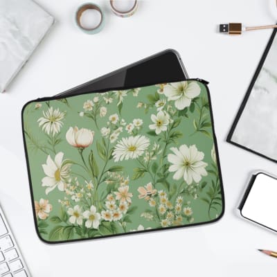 Floral laptop sleeve with white flowers and green leaves on a soft green background. laptop sleeve kept on a plain white background