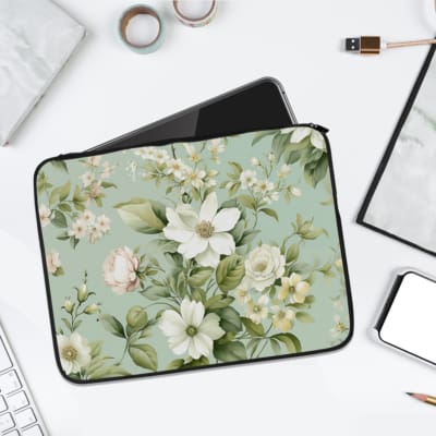 Floral laptop sleeve with white flowers and green leaves on a soft green background. laptop sleeve kept on a plain white background