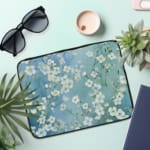 Blue floral laptop sleeve with white flower pattern, the laptop sleeve on the table