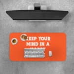 Infidu Keep Your Mind In A Happy Place Desk Pad with Motivational Orange Design Desk Pad with Keyboard and Mouse on top of the desk pad