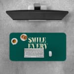 Infidu Smile Everyday Design Desk Pad featuring bold white text on a dark green background, perfect for uplifting workspaces. A desk pad under the computer