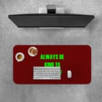 Infidu Always Be Kind To Yourself Desk Pad featuring bright green text on a maroon background, perfect for promoting self-care at your desk. A desk pad under the computer