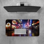 Infidu Neon City Street Design Desk Pad with a lively urban night scene, featuring neon reflections on wet pavement and silhouetted city figures. A desk pad under the computer