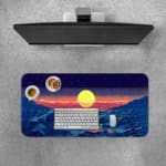 Infidu Desk Pad with an ocean sunset design, showcasing blue waves and a sky in warm tones of pink, purple, and orange for a serene look. A desk pad under the computer