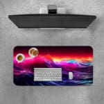 Infidu Neon Ocean Waves Design Desk Pad with vibrant shades of pink, purple, blue, and orange depicting ocean waves and sunset. A desk pad under the computer