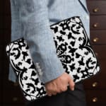 Laptop sleeve with a bold black and white floral or geometric design. the person holding the sleeve