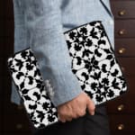 Infidu Black & White Laptop Sleeve with intricate symmetrical floral and geometric patterns, bold and stylish protective laptop case. the person holding the sleeve