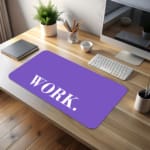 Infidu Work Desk Pad featuring the word "WORK." in white on a light purple background with a dark horizontal line above. desk pad kept on the table