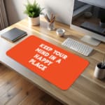 Infidu Keep Your Mind In A Happy Place Desk Pad with Motivational Orange Design desk pad kept on the table