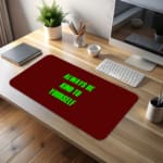 Infidu Always Be Kind To Yourself Desk Pad featuring bright green text on a maroon background, perfect for promoting self-care at your desk. desk pad kept on the table