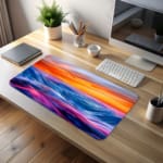 Infidu Serene Sunset Wave Design Desk Pad features colorful soft waves in blue, purple, and pink with a yellow and orange sunset. desk pad kept on the table