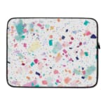 Laptop sleeve featuring a pastel terrazzo design with irregular shapes in pink, blue, turquoise, and dark shades on a light background. laptop sleeve kept on a plain white background