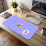 Cute bee desk pad with light blue background and playful flower design, perfect for adding a fun touch to any desk desk pad kept on the table