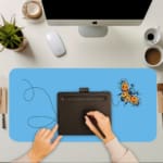 Infidu Yellow Butterfly Desk Pad featuring a yellow butterfly with a dotted flight path on a light background. A writing pad on top of the desk pad