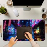 Infidu Futuristic City Desk Pad features a colorful scene with neon lights reflecting on a wet surface, perfect for a vibrant workspace. A writing pad on top of the desk pad