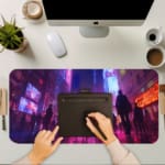 Infidu Neon City Street Design Desk Pad showcases silhouettes of people on a reflective street with vibrant neon colors. A computer and laptop are next to the desk pad