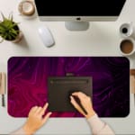 Infidu Desk Pad with a swirling marble design in shades of purple and pink, showcasing a smooth, flowing texture for a dreamy aesthetic. A writing pad on top of the desk pad