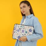 Organic abstract laptop sleeve with hand-drawn patterns in coral, purple, mint green, and black on a white background with a zip closure. The laptop sleeve covers the laptop