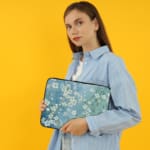 Blue floral laptop sleeve with white flower pattern, The laptop sleeve covers the laptop