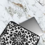 Laptop sleeve with a bold black and white floral or geometric design. The laptop sleeve covers the laptop