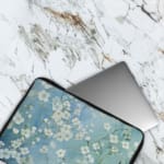 Blue floral laptop sleeve with white flower pattern, The laptop sleeve covers the laptop